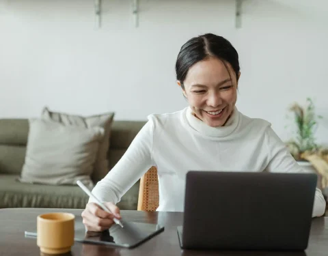 uśmiechnięta kobieta przy laptopie